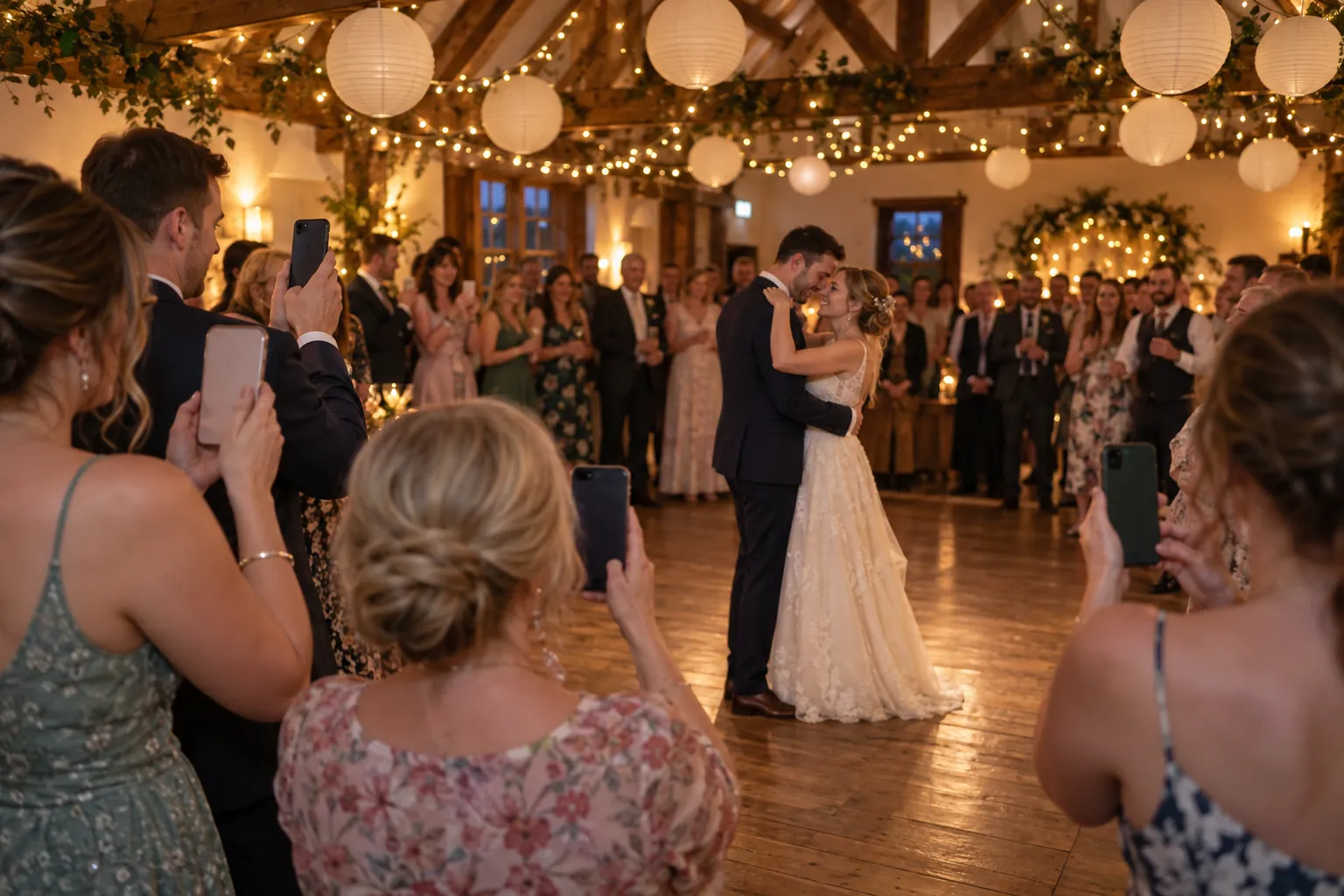 Guests at a village hall wedding photograph the first dance on their phones