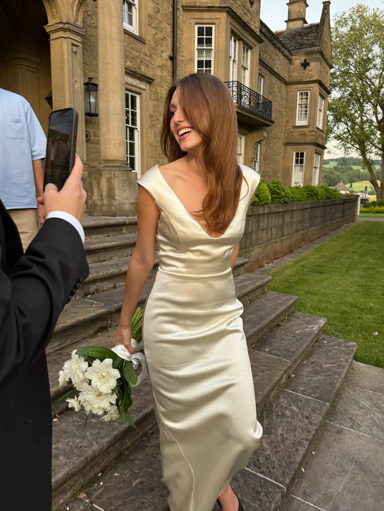 The bride laughing on the manor steps at golden hour