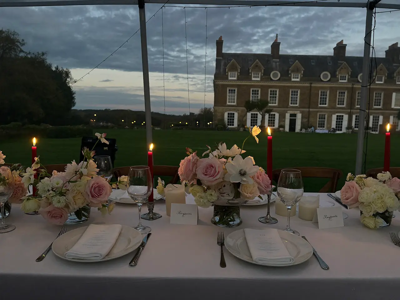 The marquee table at dusk, roses and tapered candles