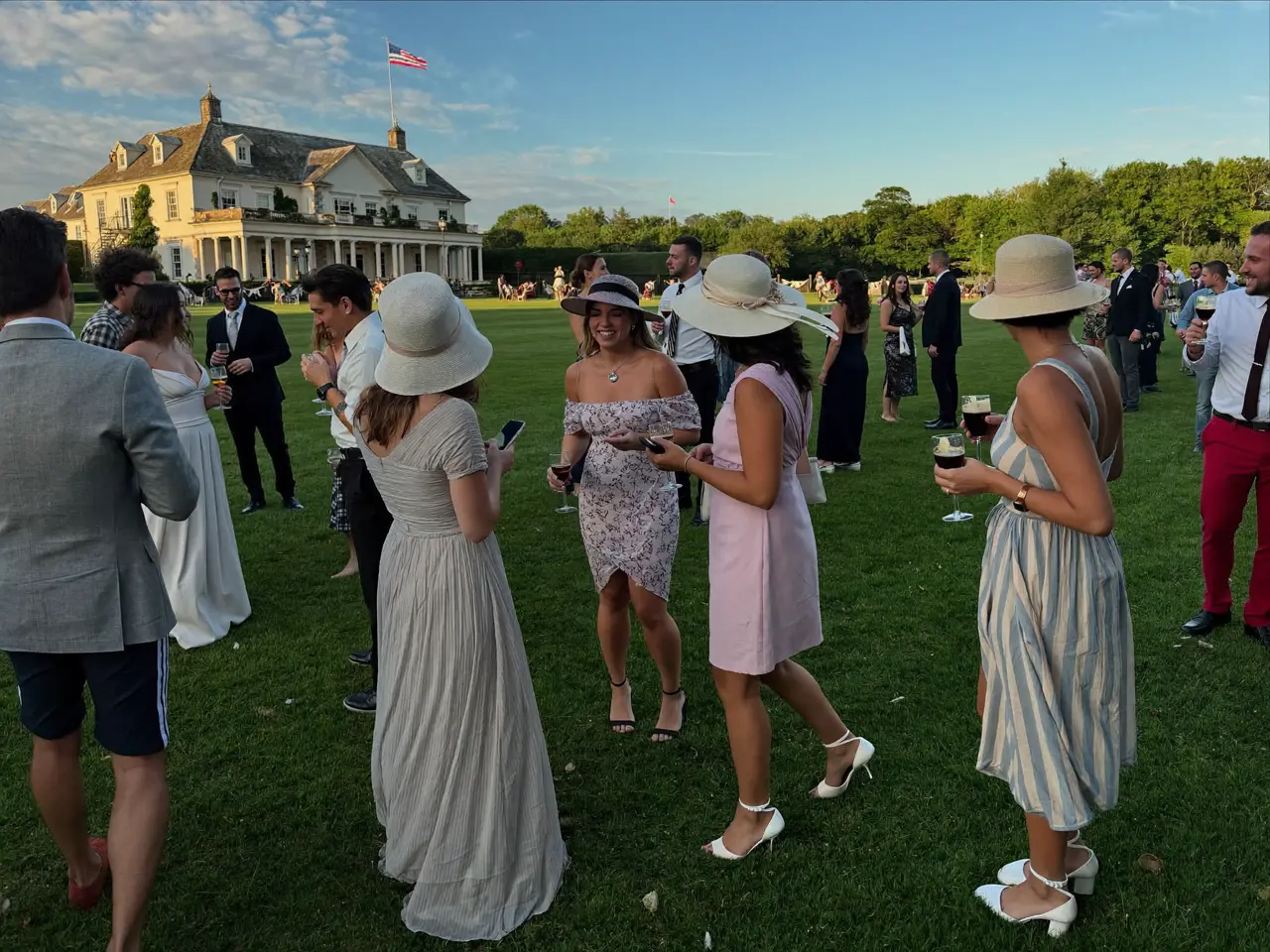 Guests mingling on the lawn at golden hour