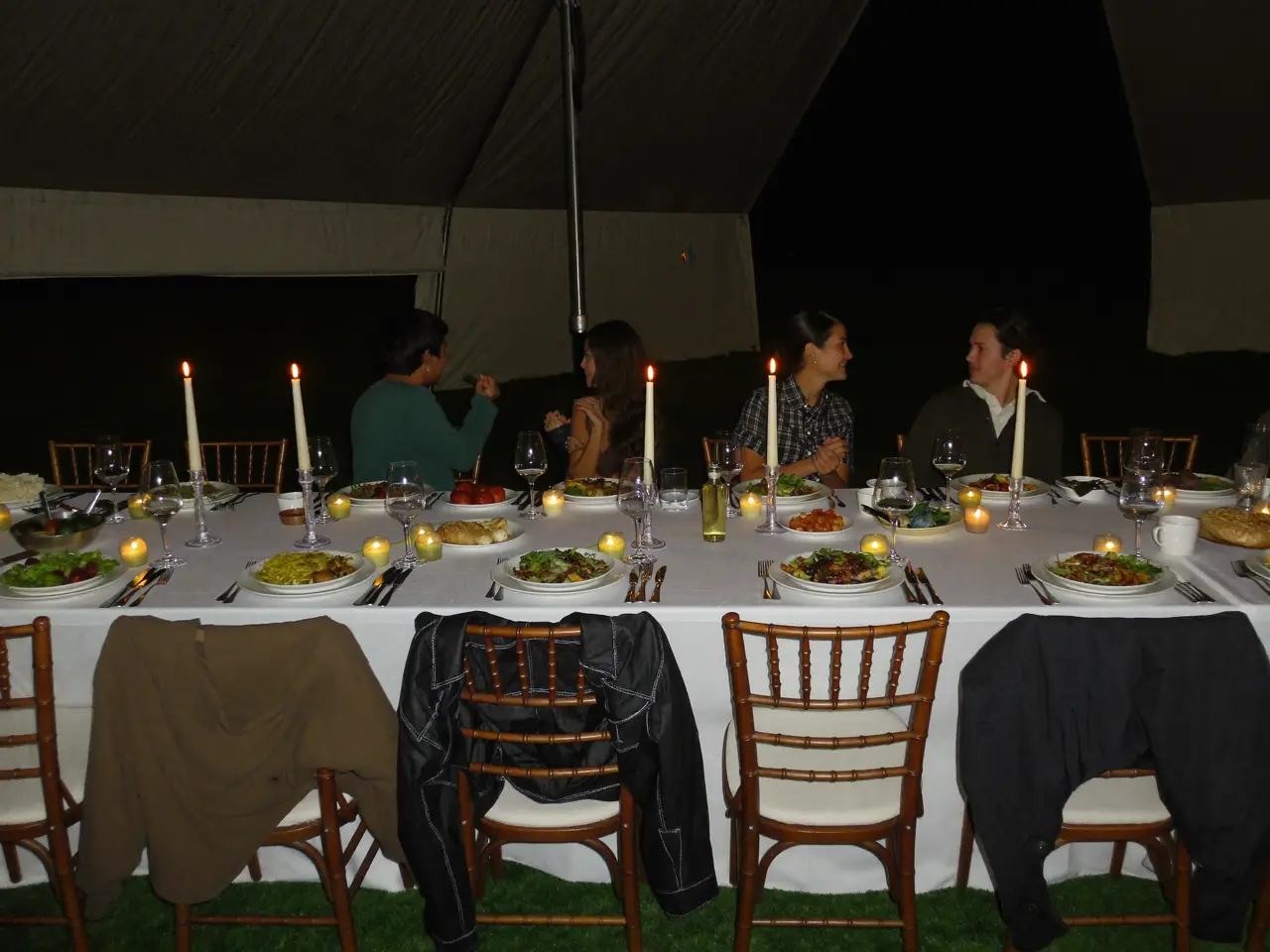 The dinner table late at night, candles burnt low