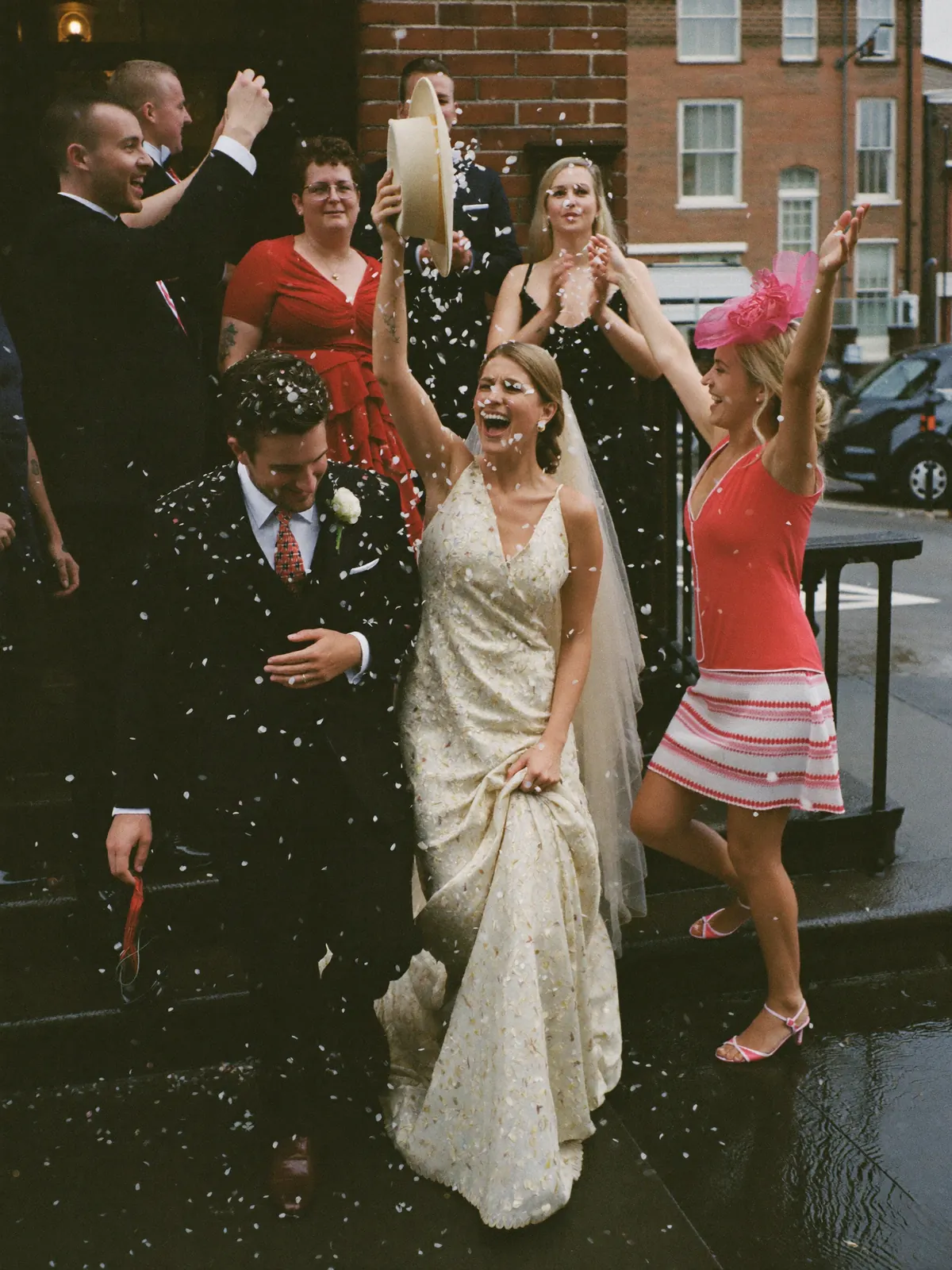 Bride and groom come down the register office steps through a shower of confetti